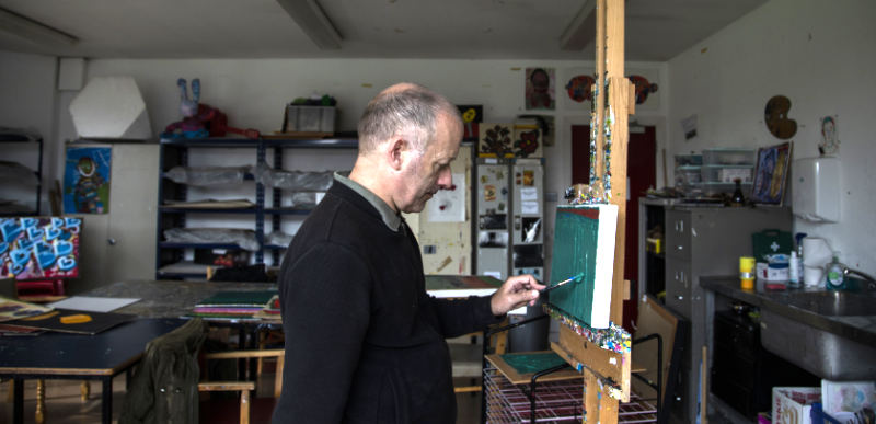 Photo of a man painting in a studio