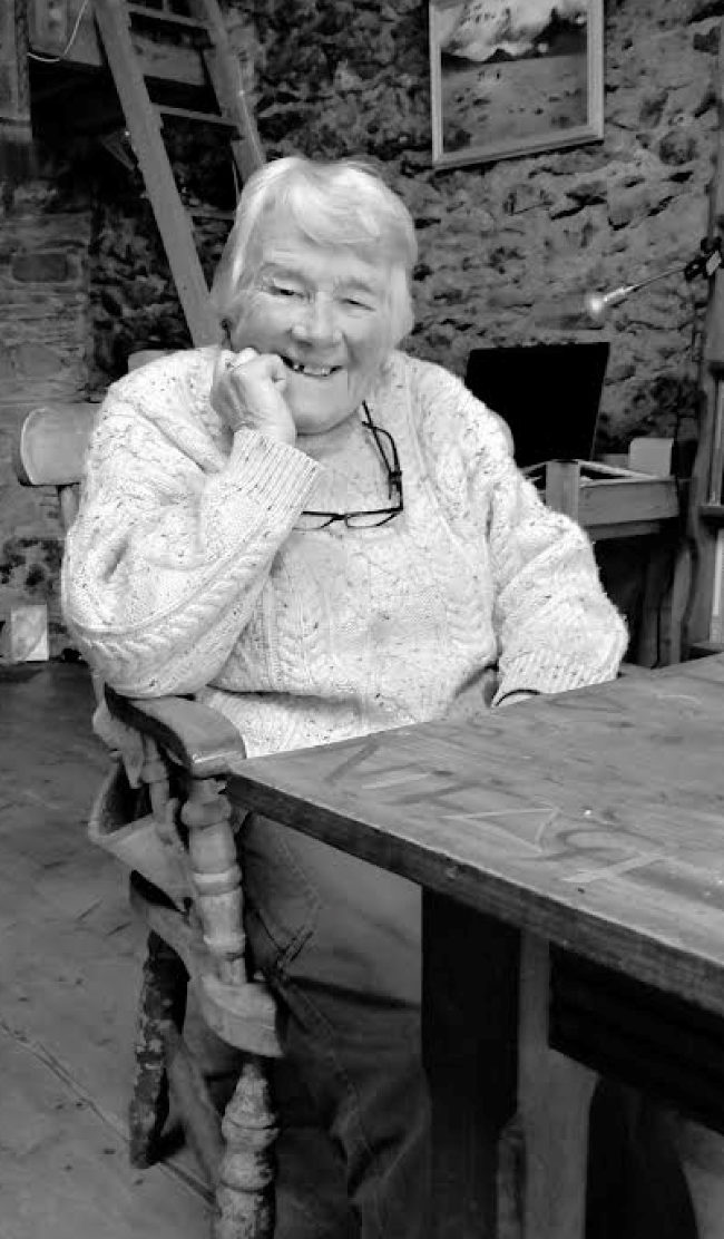 An old woman sitting at a table.