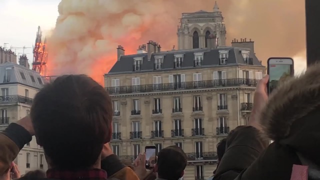 People watching a building on fire