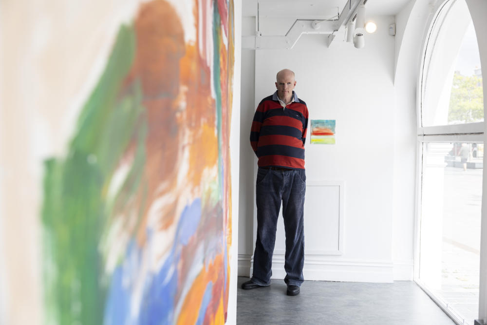 An artist in front of a painting